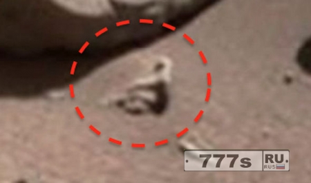 Инопланетянин сидит на поверхности Марса.