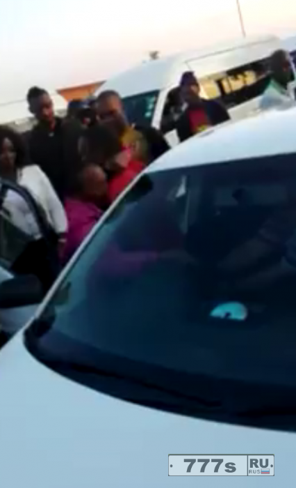 Интересный момент обиженная женщина залазит на ветровое стекло машины мужа.