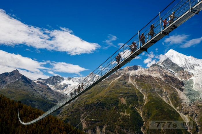 Снимки, вызывающие сосание в желудке, показывают, как храбрые туристы идут по висячему швейцарскому туристическому мосту.