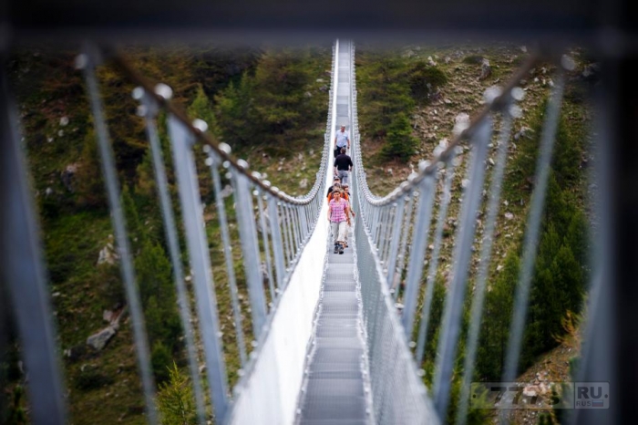 Снимки, вызывающие сосание в желудке, показывают, как храбрые туристы идут по висячему швейцарскому туристическому мосту.
