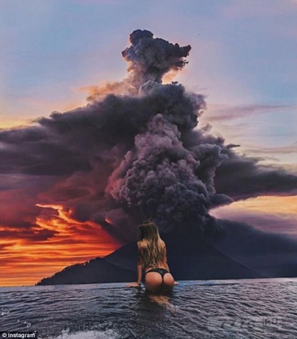 Туристы позируют в бикини перед извержением вулкана Агунг на Бали.