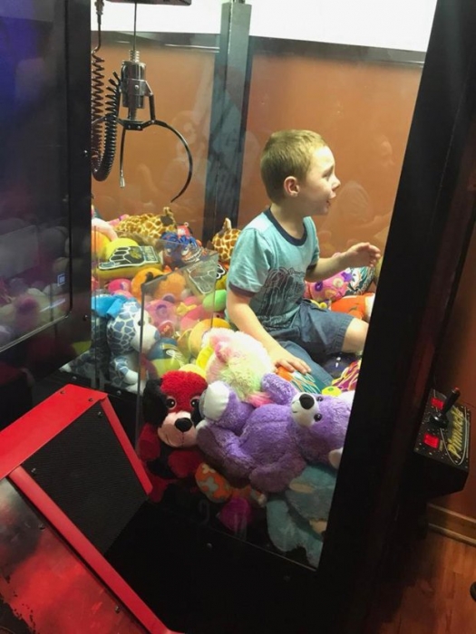 Мальчик, пытаясь достать игрушку из автомата, застрял в нем