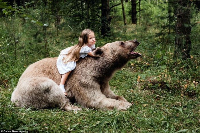 Маленькая девочка позирует с 317-килограммовым медведем гризли после того, как он был взят в семью еще детенышем
