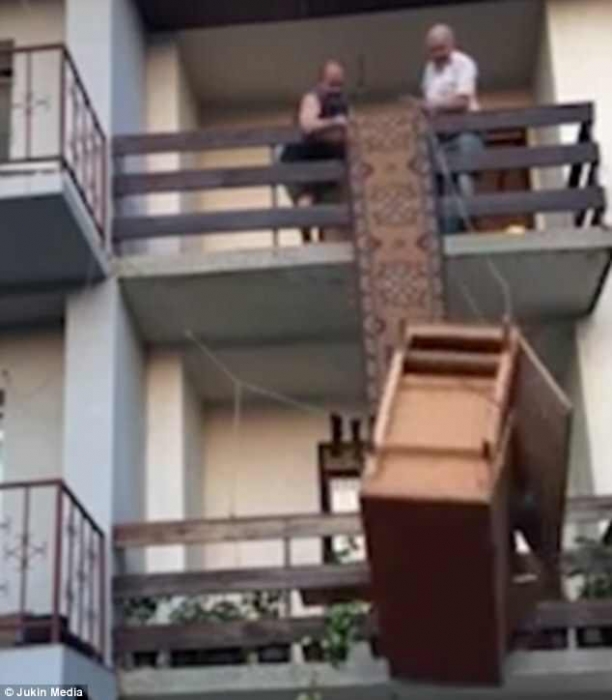 Двое мужчин пытаются спустить шкаф из квартиры второго этажа ... но все заканчивается не очень хорошо
