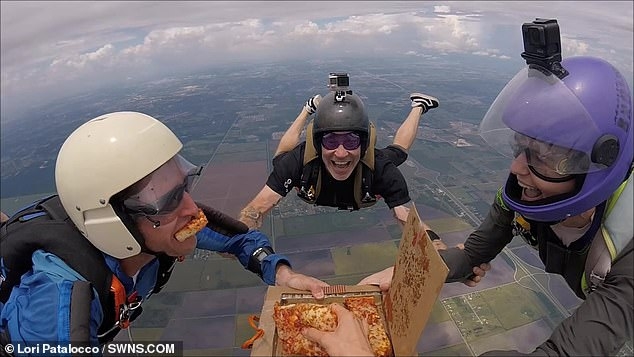 Парашютисты откусывают кусочки пиццы, когда они свободно падали на землю с высоты 4300 метров