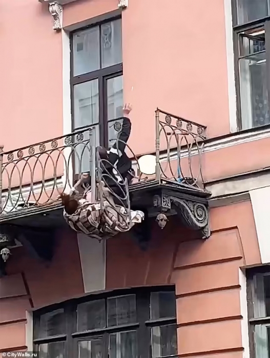 Страшный момент, когда пара падает с балкона после того, как богатые перила на балконе в  Санкт-Петербурге ломаются