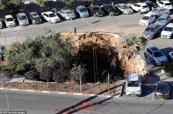 Момент, когда огромная воронка открывается и поглощает три машины на стоянке в иерусалимской больнице после того, как во время строительства рухнул туннель шоссе