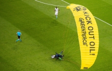   Много футбольных фанатов было госпитализировано, когда парашютист из Гринпис протестуя, приземлился на стадион во время матча